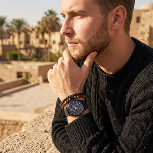 Elegant man wearing Maserati Epoca R8873618006 men's quartz battery watch with black case and luxury rose gold accented dial