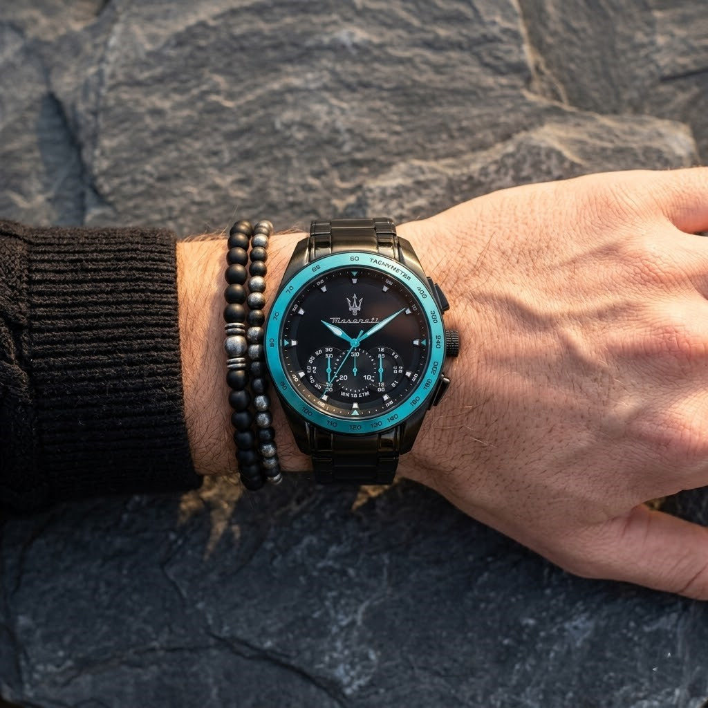 Close up of Maserati Traguardo Aqua Edition R8873644002 men's quartz battery watch on wrist showing black dial and striking aqua tachymeter bezel