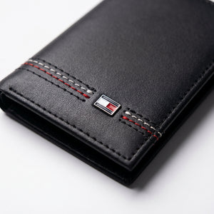 Macro close-up view showing the high-quality smooth leather texture and precision embedded Tommy Hilfiger metal enamel flag logo
