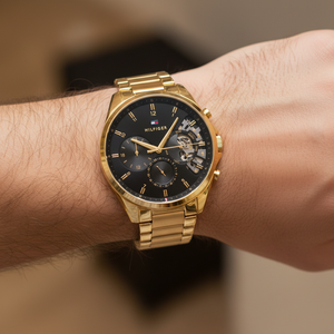 Close up shot of Tommy Hilfiger 1710447 on wrist showing the black dial with gold-tone sub-dials and luminous hands