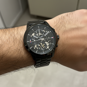 Close up shot of Tommy Hilfiger 1710478 watch on wrist showing the exposed gears and black finish
