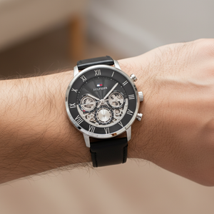 Close up shot of Tommy Hilfiger 1710565 watch on wrist showing the black skeleton dial and silver case