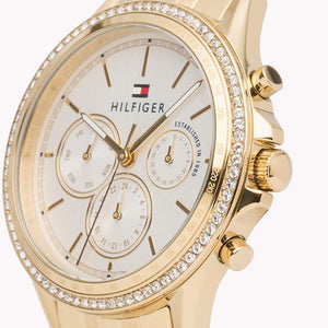 Angled view of Tommy Hilfiger 1781977 highlighting the polished gold-tone case, crystal bezel, and link bracelet