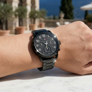 Close up shot of Tommy Hilfiger 1791423 on wrist showing the textured black dial and bold Arabic numerals with the metal bracelet shine