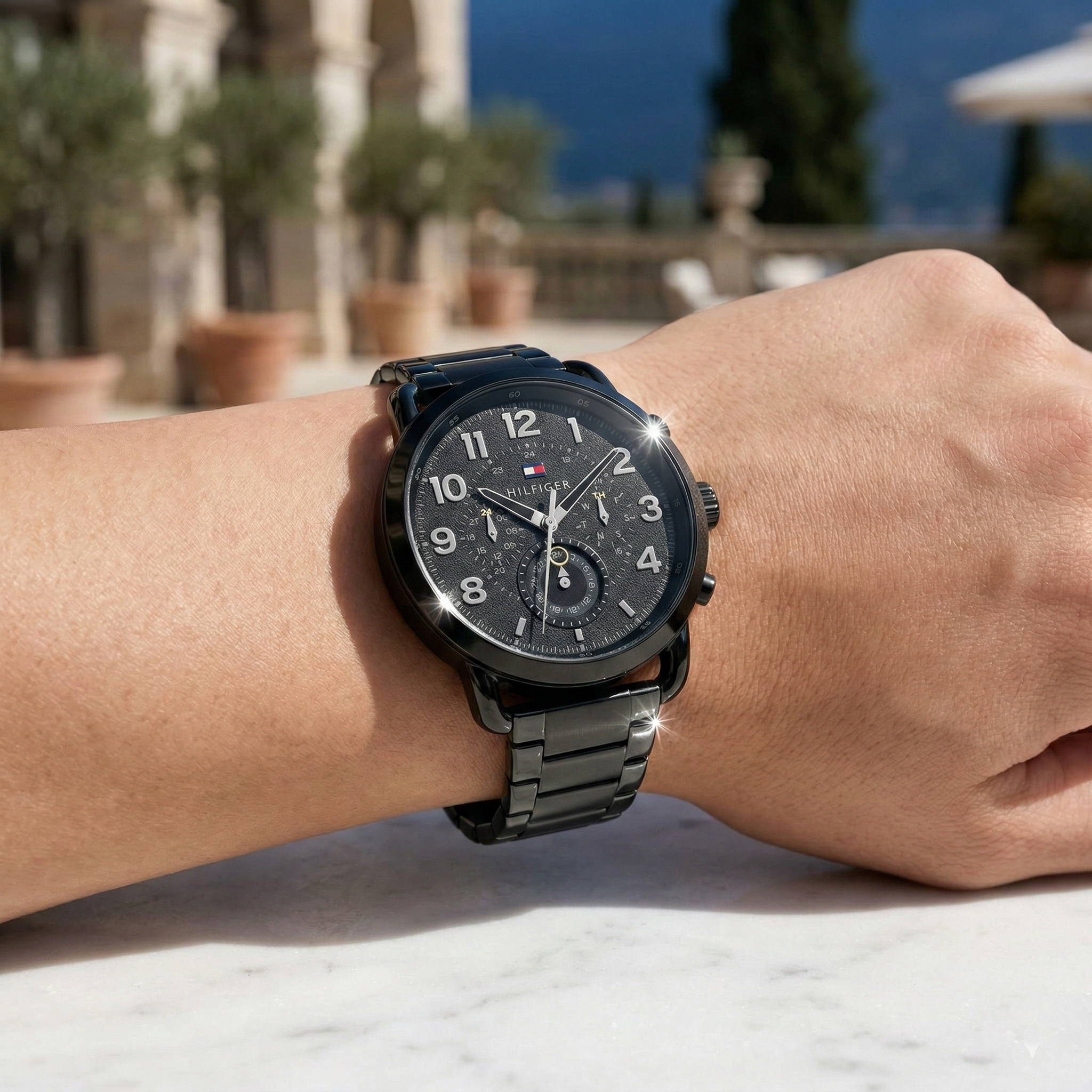 Close up shot of Tommy Hilfiger 1791423 on wrist showing the textured black dial and bold Arabic numerals with the metal bracelet shine