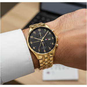 Close up shot of Tommy Hilfiger 1791708 watch on wrist showing the black dial and gold details