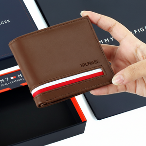 An open display of the Tommy Hilfiger men's brown leather wallet alongside its branded gift box and luxury shopping bag