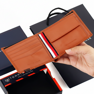 Interior view of the Tommy Hilfiger camel leather wallet featuring an organized layout with card slots, a secure buttoned coin pocket, and the signature flag ribbon