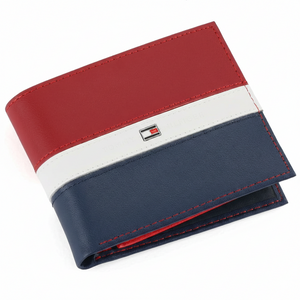 Front perspective view of a partially open Tommy Hilfiger men's genuine leather wallet showcasing the striking red, white, and navy blue color-block pattern and enamel flag logo