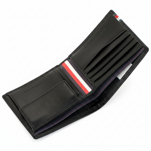 Detailed interior shot of a Tommy Hilfiger black wallet highlighting the iconic red and white flag ribbon and premium leather card compartments