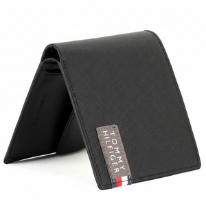 Side perspective of a standing Tommy Hilfiger black leather bifold wallet showcasing its slim profile and high-quality Saffiano finish