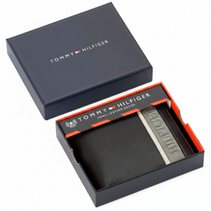 Authentic Tommy Hilfiger men's havana tan genuine leather bifold wallet with a vertical brown branding stripe, presented in its premium navy gift box