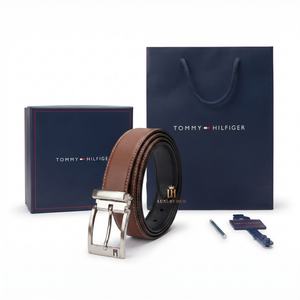 Brown belt with silver buckle in front of Tommy Hilfiger packaging on a white background