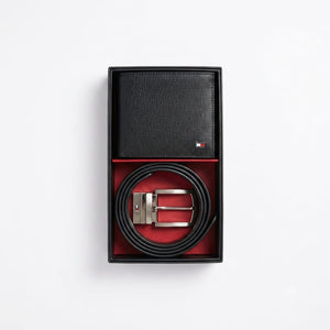 Live smartphone photograph of the Tommy Hilfiger mirror original 2-piece gift set showcasing the black smooth wallet and rolled reversible belt inside the presentation box