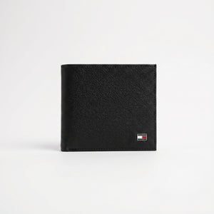 Professional angled studio photograph of the sleek Tommy Hilfiger mirror original textured black leather bifold wallet centered on white background