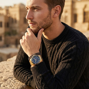 Elegant man wearing Guess Chaser W0172G5 men's quartz battery watch with gold case and luxury gold metal bracelet