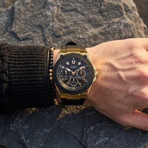 Close up of Guess Legacy W1049G5 men's quartz battery watch on wrist showing clean black dial and luxury black bezel