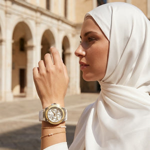 Elegant woman wearing Guess Zena W1094L1 women's quartz battery watch with silver case and luxury white rubber strap
