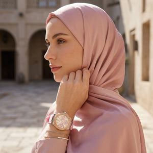 Elegant woman wearing Guess Zena W1094L4 women's quartz battery watch with silver case and luxury pink rubber strap