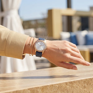 Close up of Guess Swirl W1096L4 women's quartz battery watch on wrist showing white dial and luxury crystal swirl bezel