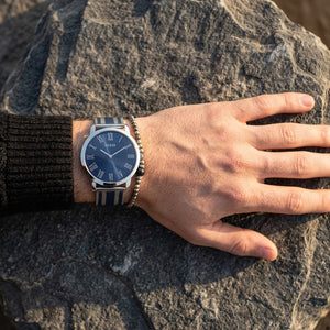 Close up of Guess W1179G1 men's quartz battery watch on wrist showing clean blue dial and silver roman numerals