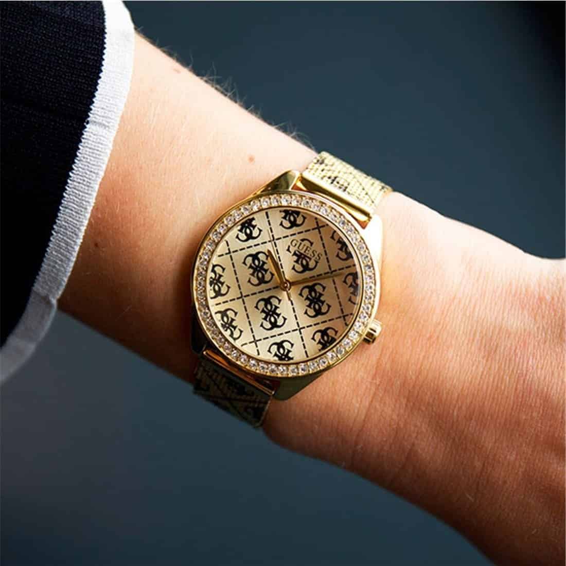Close up of Guess Claudia W1279L2 women's quartz battery watch on wrist showing black 4G logo pattern dial and luxury crystal bezel