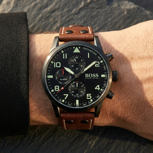 Close up of Hugo Boss Aeroliner Maxx 1513079 on wrist showing black dial and brown leather strap with 50m water resistance
