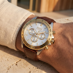 Close up of Hugo Boss Ikon 1513174 on wrist showing silver dial and gold bezel with brown leather strap 100m water resistance
