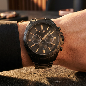 Close up of Hugo Boss Driver 1513277 on wrist showing black textured dial and gold-tone markers with black metal strap 50m water resistance