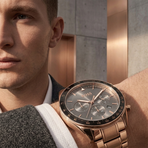 Professional man wearing Hugo Boss Trophy 1513632 with gray sunray dial and rose gold metal link strap water resistant 50m