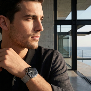Professional man wearing Hugo Boss Ocean Edition 1513701 with black dial and silver metal mesh strap water resistant 100m