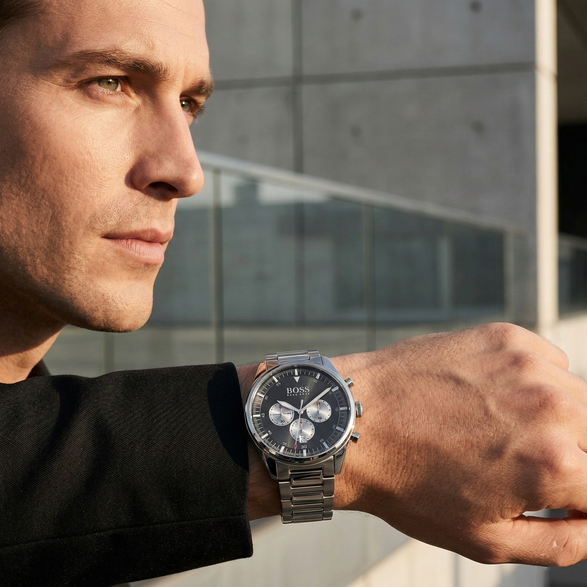 Professional man wearing Hugo Boss Pioneer 1513712 with black dial and silver metal link strap water resistant 50m