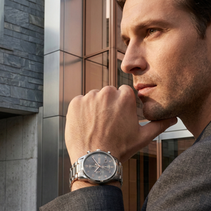 Professional traveler wearing Hugo Boss Skymaster 1513789 with gray dial and silver rose gold metal strap water resistant 50m