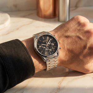 Close up of Hugo Boss Champion 1513819 on wrist showing black dial and two-tone metal strap with 100m water resistance