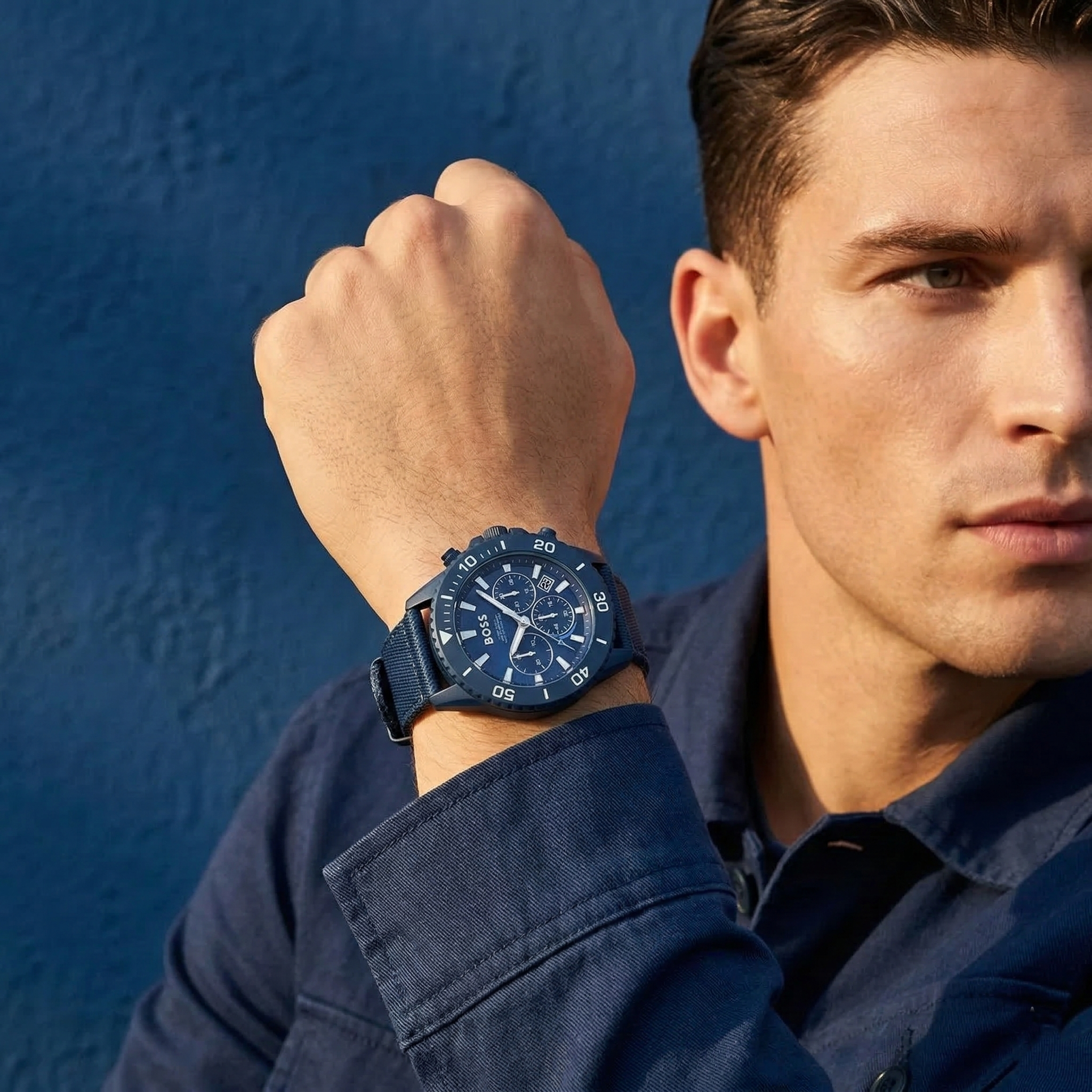 Professional man wearing Hugo Boss Admiral 1513919 solar powered watch made from recycled ocean plastic with blue fiber strap