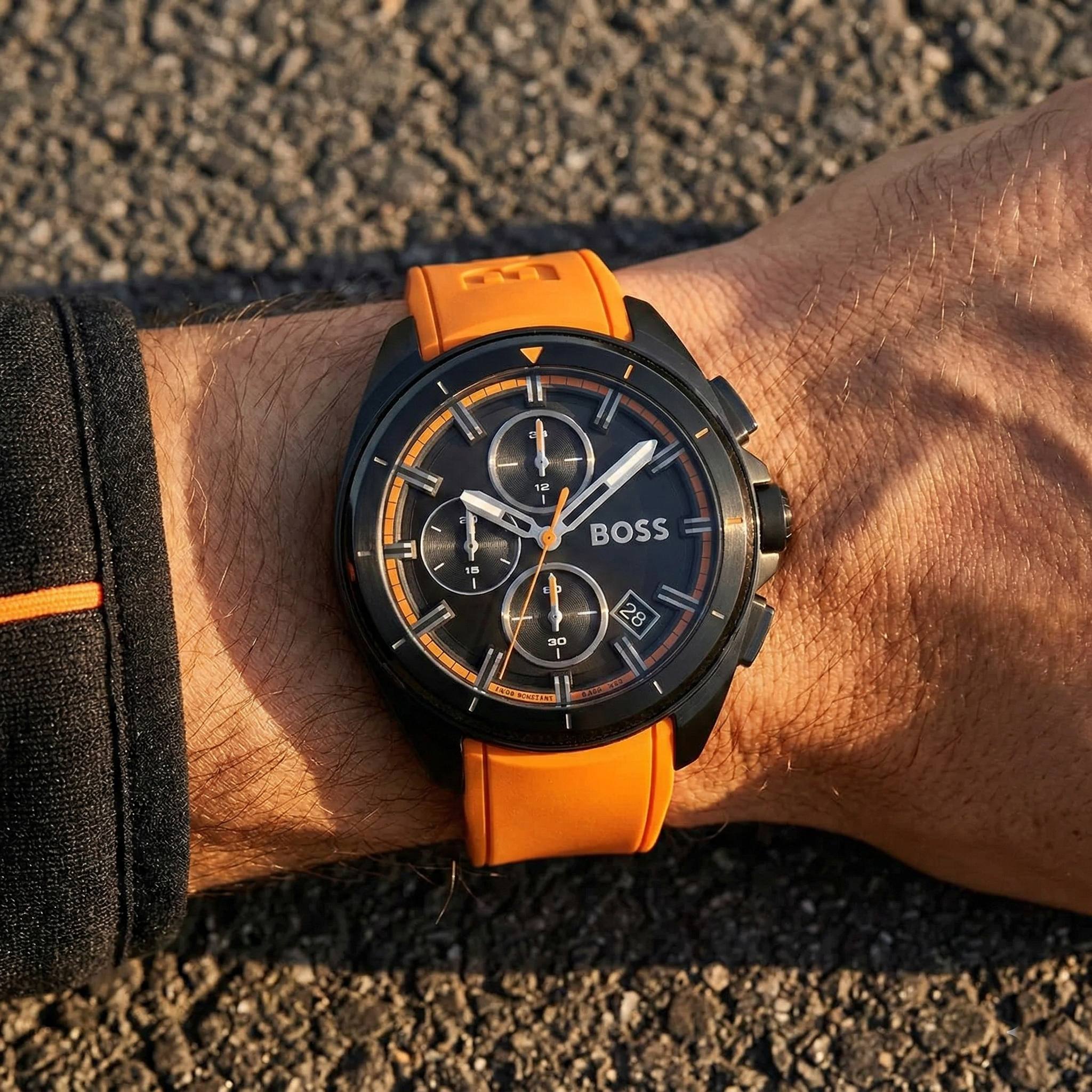 Close up of Hugo Boss Volane 1513957 on wrist showing black dial and orange rubber strap with 50m water resistance