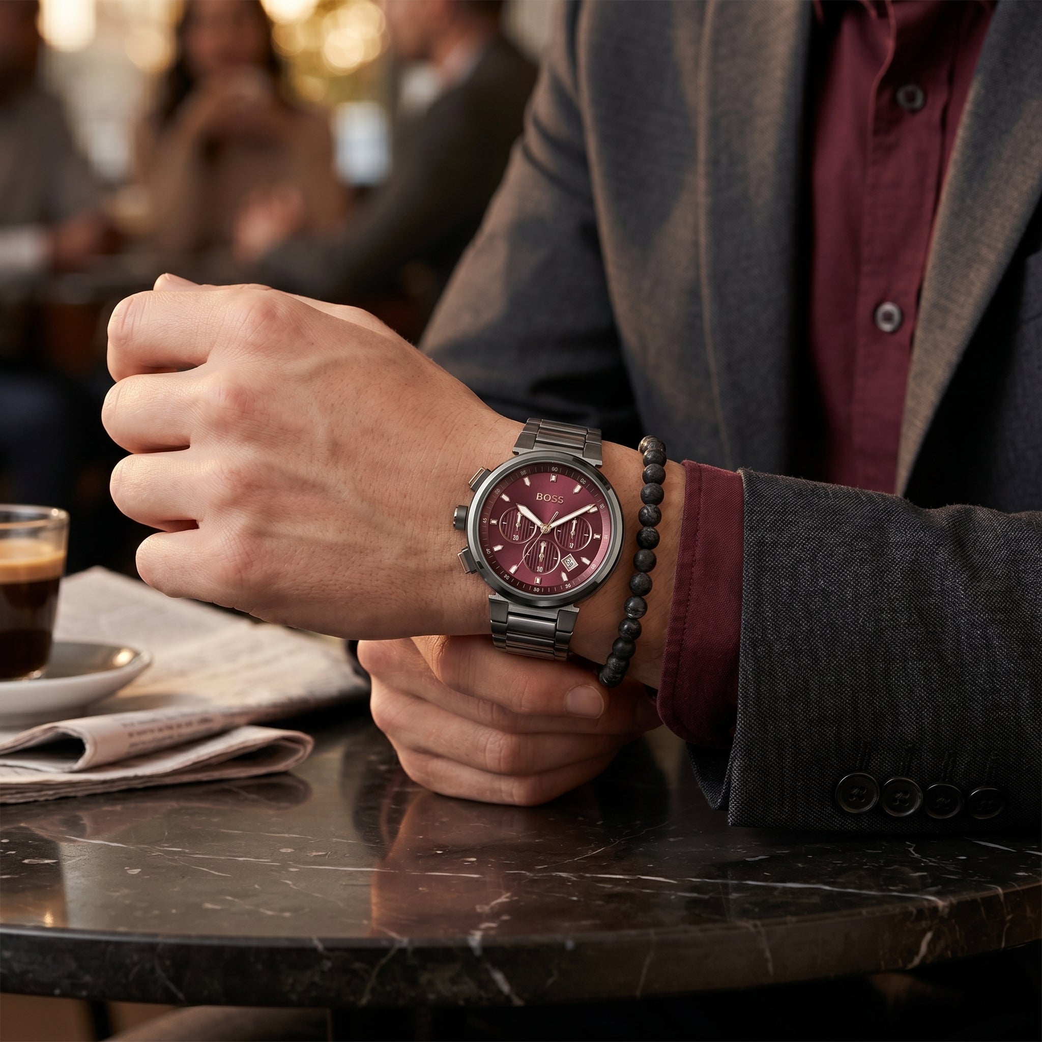 Lifestyle photo of Boss One 1514000 showing the bold gunmetal and red watch on a man's wrist in a professional setting from Luxury Hub Store