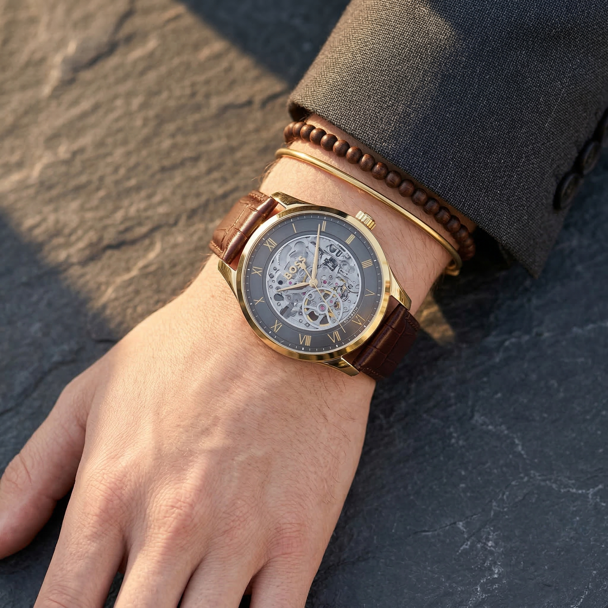 Close up of Hugo Boss Principe 1514235 men's automatic watch on wrist showing intricate dark grey skeleton dial and brown leather strap