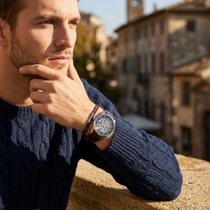 Elegant man wearing Hugo Boss Principe 1514305 men's automatic watch with silver-tone case and luxury skeleton dial