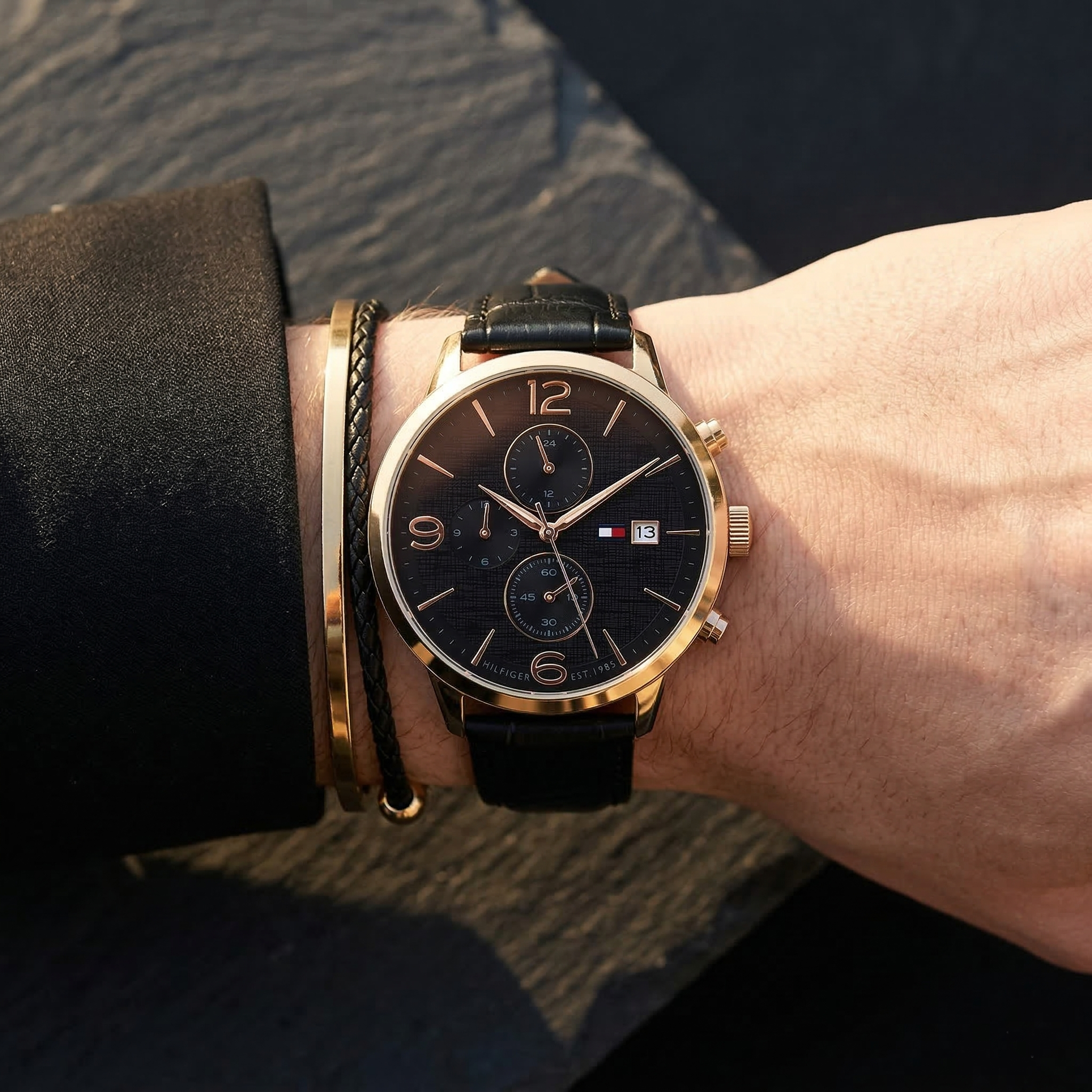 Close up of Tommy Hilfiger Liam 1710358 men's quartz battery watch on wrist showing black textured dial and black leather strap