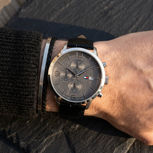 Close up of Tommy Hilfiger Liam 1710361 men's quartz battery watch on wrist showing gray textured dial and black leather strap
