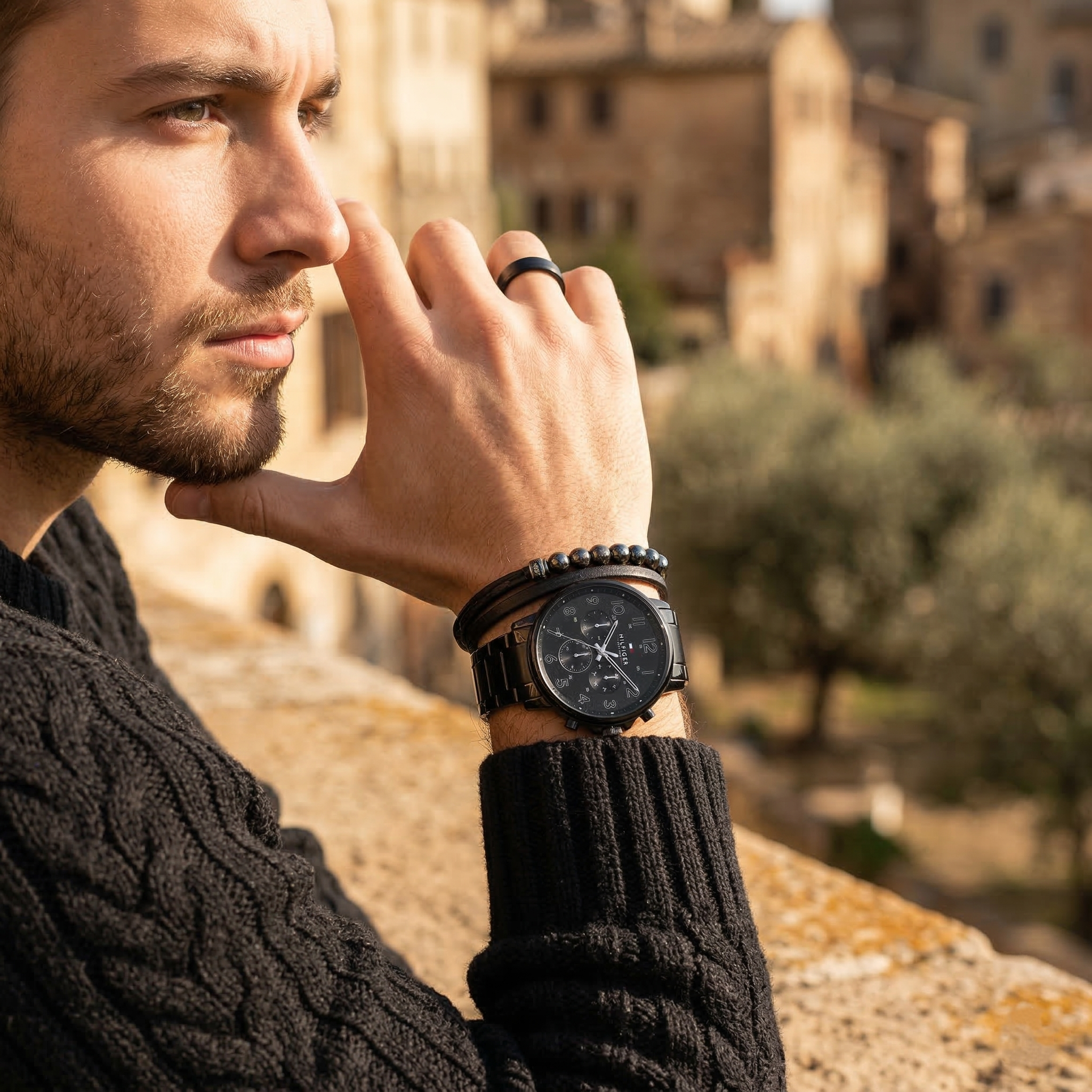 Elegant man wearing Tommy Hilfiger Daniel 1710383 men's quartz battery watch with black-tone case and luxury logo dial