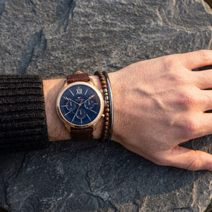 Close up of Tommy Hilfiger Morrison 1710526 men's quartz battery watch on wrist showing navy blue dial and luxury gold-tone markers