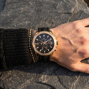 Close up of Tommy Hilfiger Lars  1710650 men's quartz battery watch on wrist showing black waffle dial and luxury rose gold accents