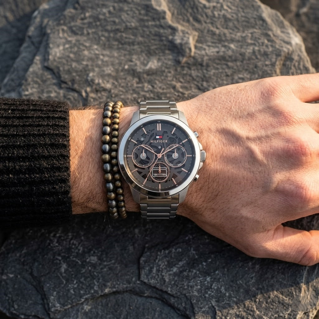 Close up of Tommy Hilfiger Henry 1710683 men's quartz battery watch on wrist showing grey skeleton dial and luxury rose gold markers