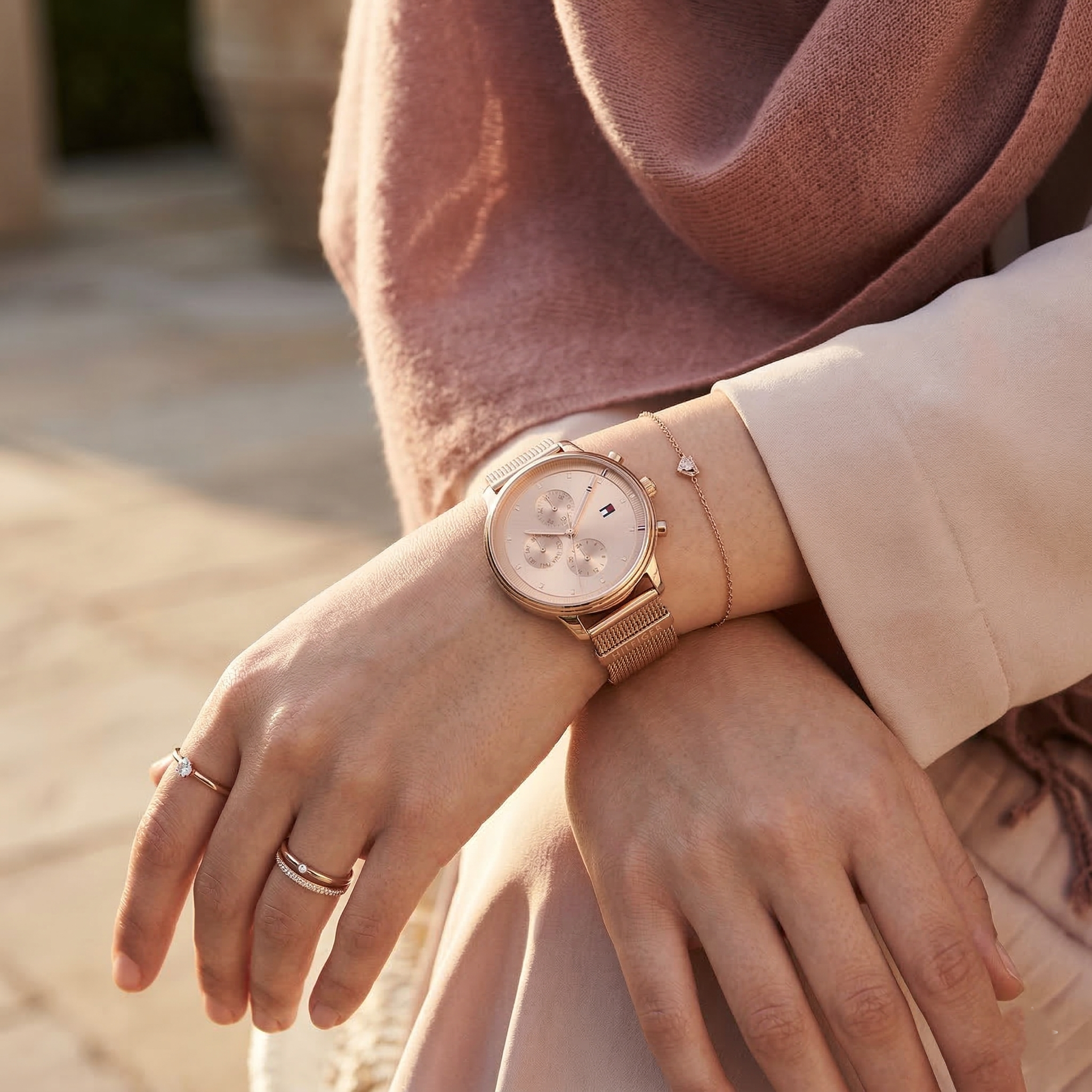 Elegant woman wearing Tommy Hilfiger 1781907 women's quartz battery watch with rose gold case and luxury mesh strap