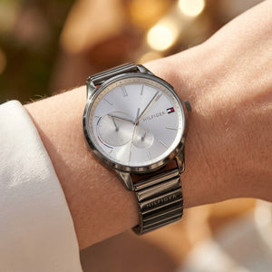 Silver Tommy Hilfiger watch on a wrist with a blurred background
