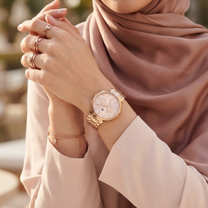 Close up of Tommy Hilfiger Ivy 1782345 women's quartz battery watch on wrist showing pink sunray dial and rose gold metal bracelet