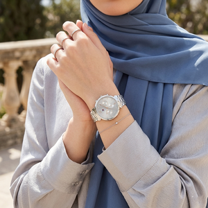 Elegant woman wearing Tommy Hilfiger Ivy 1782346 women's quartz battery watch with silver-tone case and luxury gray dial