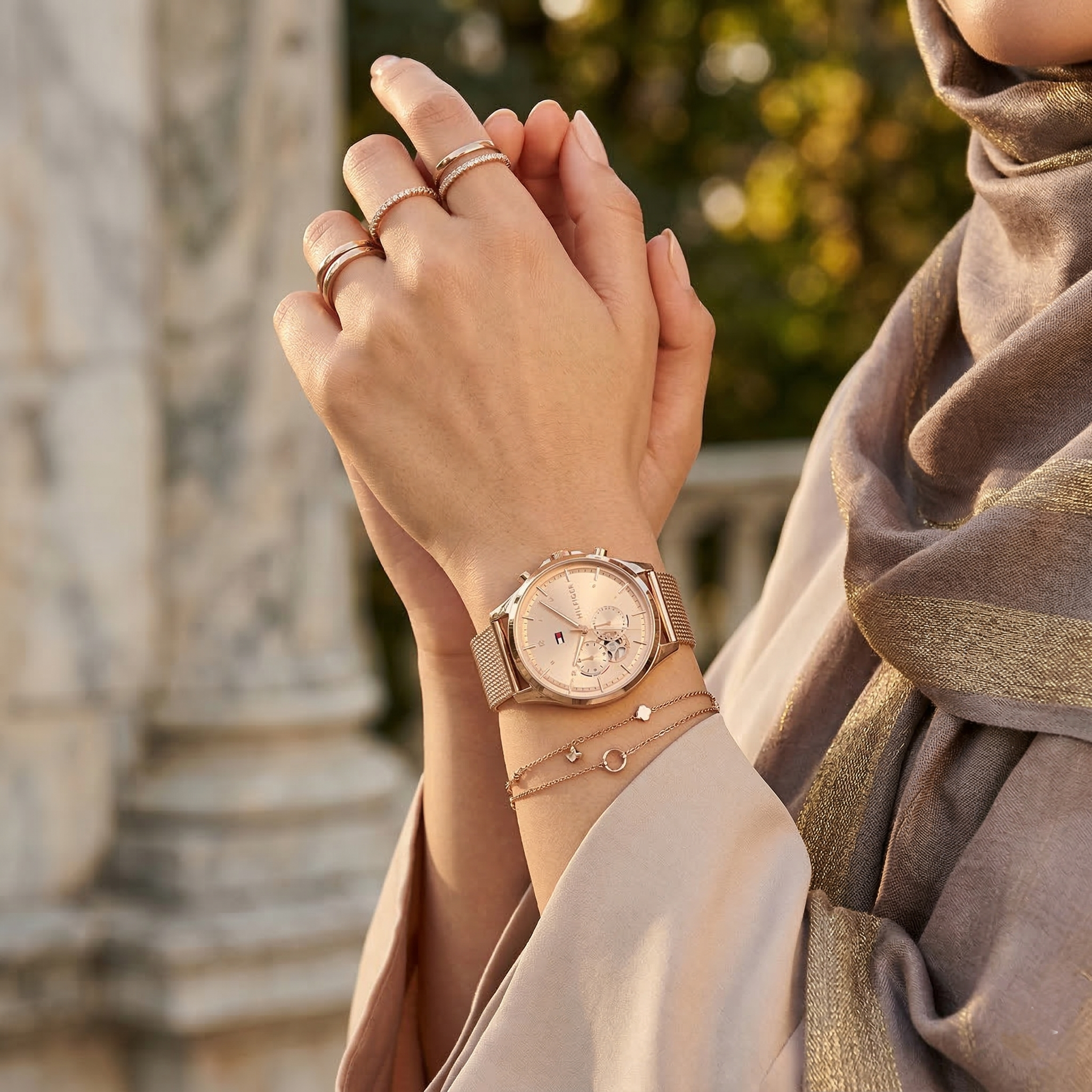 Elegant woman wearing Tommy Hilfiger Quinn 1782486 women's quartz battery watch with rose gold case and luxury mesh strap